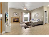 Bright living room with fireplace, tile floors, ceiling fan, and sliding door to the outside at 108 Lemon Glaze St # 202, Las Vegas, NV 89145