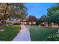 Charming brick home with lush green lawn and stone pathway leading to the entrance at 2001 Silver Ave, Las Vegas, NV 89102