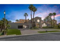 Stunning home featuring a tiled roof, palm trees, landscaped yard, and a paved driveway to attached garage at 2925 Coast Line Ct, Las Vegas, NV 89117