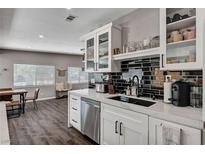 This kitchen features white cabinets, stainless steel appliances and a black tiled backsplash at 3013 Roseville Way, Las Vegas, NV 89102