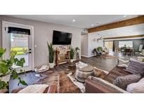 A stylish living room with a leather sofa, plants, and wood-look flooring offers comfortable living at 3013 Roseville Way, Las Vegas, NV 89102