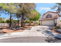Charming home exterior features a two-car garage, desert landscaping, and mature trees in a residential neighborhood at 3200 Mariner Bay St, Las Vegas, NV 89117