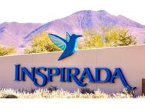 Inspira community welcome sign with mountain backdrop and blue hummingbird emblem at 3447 Sw Covilha Ln, Henderson, NV 89044