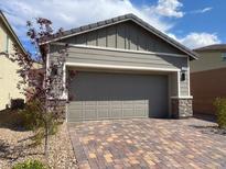 Home exterior with a two car garage and a brick driveway at 3447 Sw Covilha Ln, Henderson, NV 89044