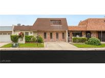 Charming brick home featuring a unique architectural design and well-maintained front yard at 3471 One Nation Ave, Las Vegas, NV 89121