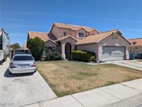 Two-story home featuring a desert landscape, tile roof, and attached two car garage at 5004 Deep Forest Dr, Las Vegas, NV 89130