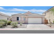 Charming single-story home featuring a tile roof, two car garage, and desert landscaping at 5517 Meridian Rain St, North Las Vegas, NV 89031