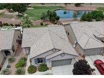 An aerial view of a single-Gathering home with a golf course and water feature in the background at 5845 Swan Point Pl, Las Vegas, NV 89122