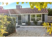Charming single-story home featuring a tile roof, gray siding, and a white rock landscaped front yard at 620 Avenue H, Boulder City, NV 89005