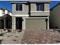 Charming two-story home featuring a brick driveway and a neutral-colored exterior with an attached two-car garage at 8020 Texas Hills St, Las Vegas, NV 89113