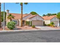 Charming single-story home boasts a tile roof and a two-car garage, enhanced by mature landscaping and a well-maintained lawn at 9116 Cypress Point Way, Las Vegas, NV 89117