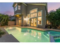 A gorgeous home featuring a private pool and spa with large glass windows and sliding glass doors overlooking the backyard at 912 Pro Players Dr, Las Vegas, NV 89134