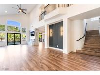 Bright living room with hardwood floors, fireplace, high ceilings and expansive windows with backyard view at 912 Pro Players Dr, Las Vegas, NV 89134