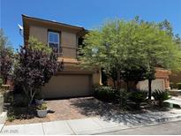 Charming two-story home featuring mature trees, a brick driveway, and an attached two-car garage at 10526 Harvest Wind Dr, Las Vegas, NV 89135