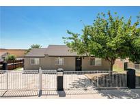 Charming single story home with a secure white fence and mature shade tree, offers a welcoming curb appeal at 125 S 15Th St, Las Vegas, NV 89101