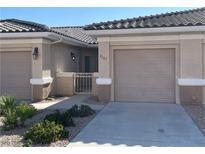 Inviting home exterior with a neutral color palette, landscaped yard, and charming gated courtyard entrance at 3161 Quail Song Dr # 3161, Laughlin, NV 89029