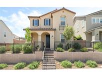 Charming two-story home with a landscaped front yard, black fence, and stairs leading to an arched doorway at 3641 Portici Ln, Henderson, NV 89044