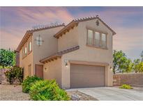 Two-story home features a neutral-colored exterior, attached garage, and desert landscaping at 389 Fringe Ruff Dr, Las Vegas, NV 89148