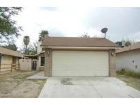 Home exterior featuring a spacious garage with a tan concrete driveway and satellite dish at 4028 Saguaro Ln, Las Vegas, NV 89110