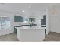 Bright kitchen featuring green cabinets, white marble countertops, and stainless steel appliances at 4369 Meadowlark Wing Way, North Las Vegas, NV 89084