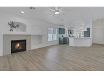 Bright open-concept living room with fireplace and views into kitchen featuring a modern design at 4369 Meadowlark Wing Way, North Las Vegas, NV 89084
