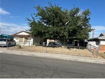 Charming single story home with mature landscaping and a chain link fence at 712 Donner St, Las Vegas, NV 89107