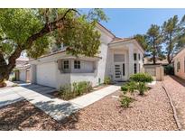 Inviting two-story home with stucco exterior, two car garage, and manicured desert landscaping at 8021 Hilliard Ave, Las Vegas, NV 89128