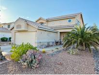 Charming front exterior showcasing desert landscaping, palm trees and a two-car garage, with a charming entry at 1068 African Eagle Ave, Henderson, NV 89015