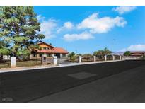 Charming home with a secure gated entrance and lush green trees, offering both privacy and curb appeal at 1385 Morning Sun Way, Las Vegas, NV 89110