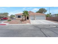 Charming single-story home featuring a three-car garage, desert landscaping, and a tile roof at 2640 Torch Ave, North Las Vegas, NV 89081