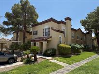 Charming two-story condo with tan stucco, tile roof, and manicured landscaping under a bright blue sky at 2801 N Rainbow Blvd # 166, Las Vegas, NV 89108