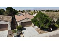 Inviting single-story home featuring a two-car garage, desert landscaping, and solar panels at 5439 E Cansano St, Pahrump, NV 89061