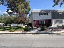 Charming townhome exterior featuring mature trees and a well-maintained landscaped front yard at 565 Greenbriar Townhouse Way, Las Vegas, NV 89121