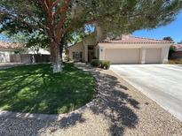 Charming home with a well-maintained lawn, large shade tree, and convenient two-car garage at 5908 Marbrisas Ln, Las Vegas, NV 89130