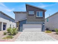 Modern two-story home featuring a two-car garage, neutral color palette and low maintenance landscaping at 66 Chelsea Manor Ct, Las Vegas, NV 89110