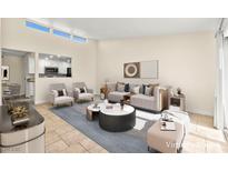 Bright living room featuring neutral tones, stylish furnishings, and seamless access to the kitchen, perfect for modern living at 727 Heritage Vista Ave, Henderson, NV 89015