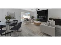 Bright living room with modern furnishings, fireplace, and sliding glass door to the backyard at 9541 Summersweet Ct, Las Vegas, NV 89123