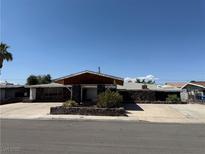 Single-story home with a wide driveway, desert landscaping, and a stone facade at 1674 Seneca Ln, Las Vegas, NV 89169