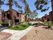 Charming complex with stucco exteriors, lush landscaping and manicured walkways create welcoming and inviting curb appeal at 4050 Pacific Harbors Dr # 224, Las Vegas, NV 89121