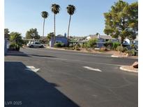 Residential street scene with palm trees, parking, and well-maintained landscaping at 5841 Medallion Dr # 102, Las Vegas, NV 89122