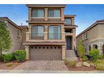 Charming three-story home featuring a balcony, two-car garage, and desert landscaping at 6056 Atlantis Dream Ave, Las Vegas, NV 89139