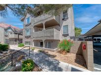 Condominium building featuring a textured facade, landscaped walkway, and covered parking at 701 Capri Dr # 6A, Boulder City, NV 89005