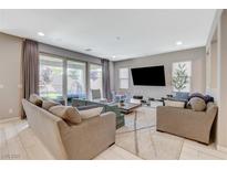 Bright living room with large window doors offering backyard views and contemporary decor at 8531 W Oquendo Rd, Las Vegas, NV 89113