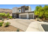 Stunning two-story home featuring a three-car garage and desert landscaping at 865 Auroras Edge Ct, Henderson, NV 89012