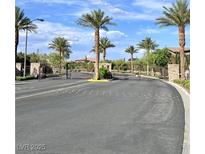 Community entrance featuring palm trees, gates, and desert landscaping creating an inviting atmosphere at 3114 Molinos Dr, Las Vegas, NV 89141