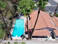 A refreshing backyard pool features a diving board, with the home having a red-tiled roof and mature landscaping at 349 Esquina Dr, Henderson, NV 89014