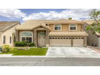 Inviting two-story home featuring a three-car garage, manicured lawn, and stone accents at 3692 River Canyon Rd, Las Vegas, NV 89129