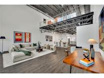 Bright, modern living room featuring a spacious seating area, unique overhead loft, and stylish decor with an open floor plan at 5015 Thunder River Cir, Las Vegas, NV 89148