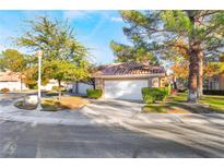 Charming home featuring manicured landscaping, a two-car garage, and a classic tiled roof at 5058 Crooked Stick Way, Las Vegas, NV 89113