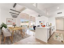 Bright, open-concept kitchen and dining area with modern lighting, quartz countertops and patio access at 6205 Hargrove Ave, Las Vegas, NV 89107